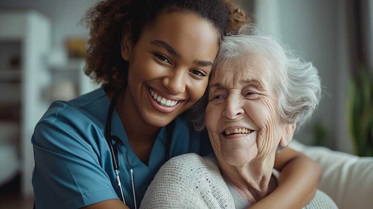 An older adult chats with a staff member in a comfortable assisted living lounge during a temporary stay.